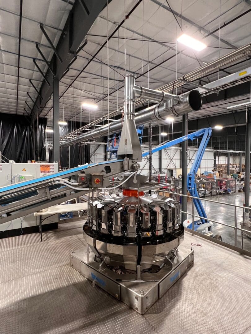 Stainless steel aspiration ducting above almond bagging scale station in food processing facility - SAI